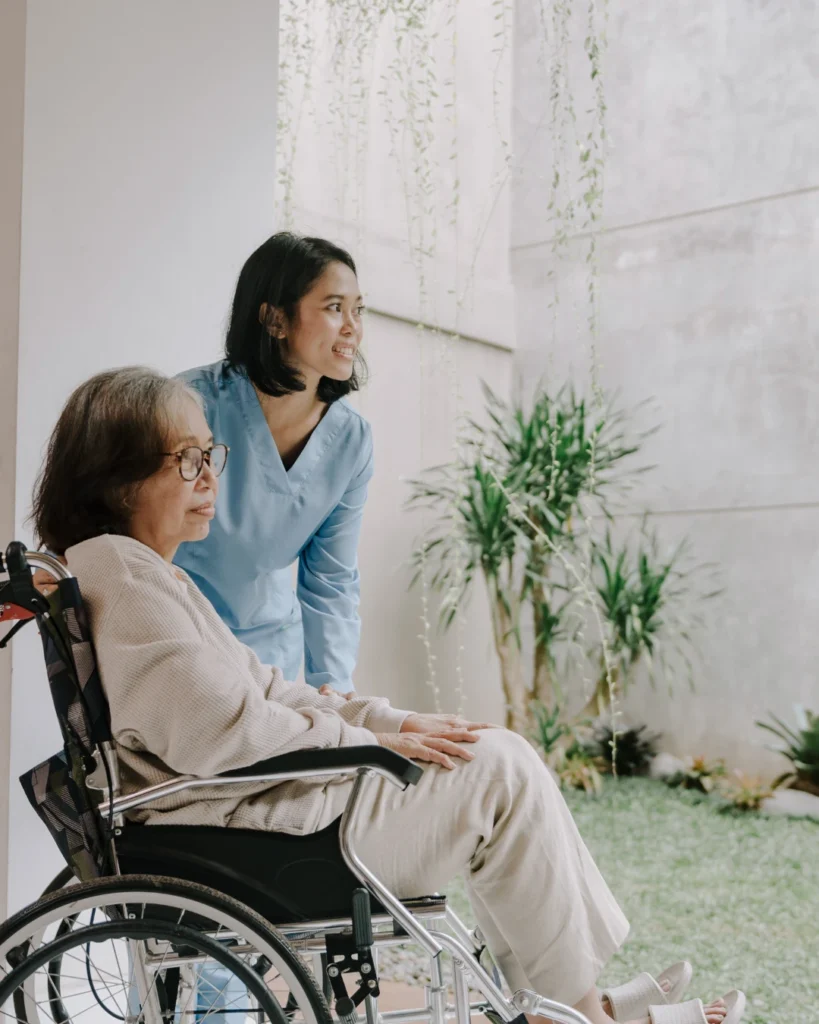 caregiver helping elderly woman in wheelchair