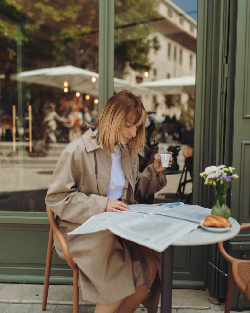 woman reading newspaper at cafe woman reading newspaper at cafe